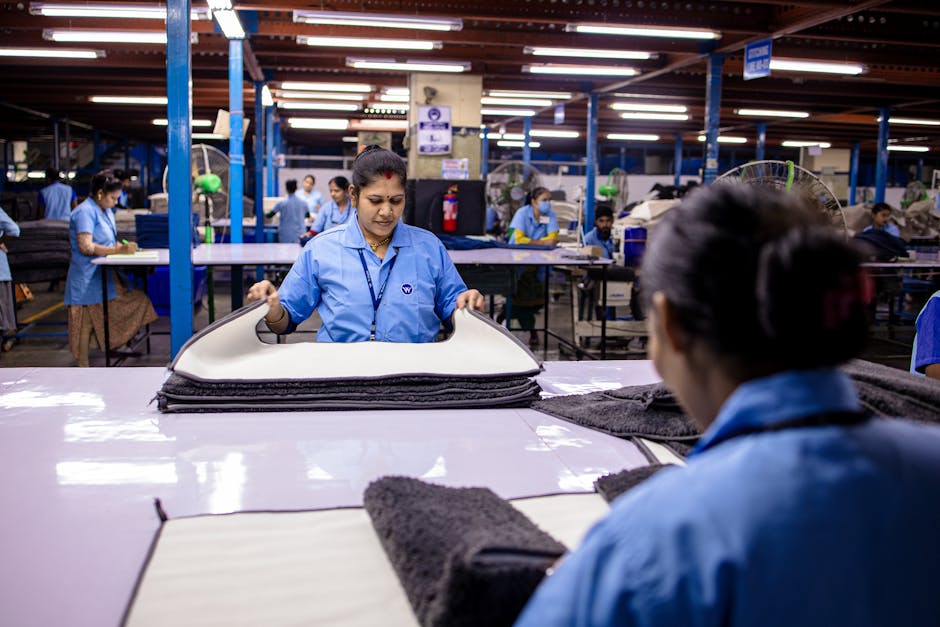 Indian workers in textile factory folding materials on production line
